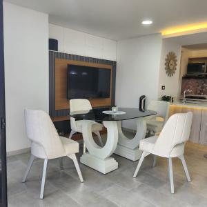 a dining room with a table and white chairs at Luxury Jacuzzi in Poblado in El Poblado +9 photos