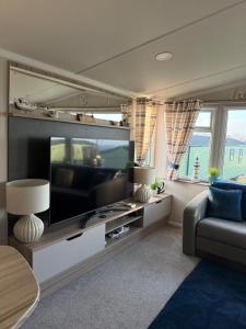 a living room with a large flat screen tv at Beach View Eden Heights Kinkell Braes 2 bedrooms 2 bathrooms in St. Andrews