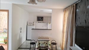 a small kitchen with a table and two stools at Sidnei Ferreira da Silva in Presidente Prudente
