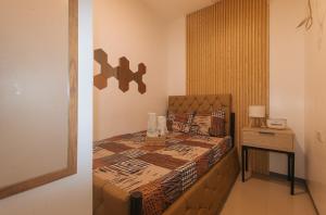 a bedroom with a bed with a wooden head board at G Fam Transient by RedDoorz in Manila