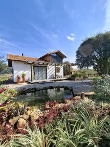 a house with a pond in front of it at Cabana Morro das Pedras in Armazém