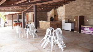 a group of white chairs sitting on a patio at Sítio Resenha in Caucaia