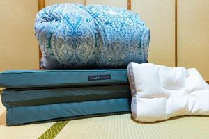 a blue and white pillow sitting on top of a mattress at 勝山恐竜博物館まで車で10分最大10名様ふとん屋の宿 悦 in Katsuyama
