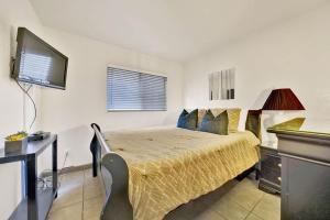 a bedroom with a bed and a desk and a television at Contemporary Value Duplex with Rooftop Deck- 303 home in Newport Beach