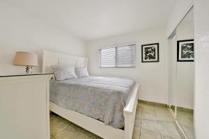 a white bedroom with a bed and a window at Contemporary Value Duplex with Rooftop Deck- 303 home in Newport Beach