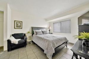 a bedroom with a bed and a chair at Contemporary Value Duplex with Rooftop Deck- 303 home in Newport Beach