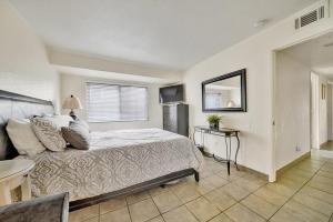 a bedroom with a bed and a table and a mirror at Contemporary Value Duplex with Rooftop Deck- 303 home in Newport Beach +20 photos