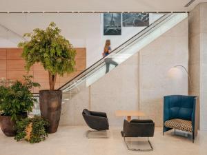 a staircase with two chairs and a table and a tree at Novotel Paris Centre Tour Eiffel in Paris