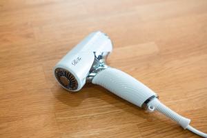 a white electric toothbrush sitting on a wooden table at Ranjatai Premium in Nara