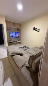 a bedroom with a large bed and a flat screen tv at RANCHO KWILL in Serra Negra