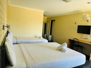 a hotel room with two beds and a tv at Wee Waa Motel in Wee Waa