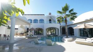 a villa with a swimming pool and palm trees at Grand De Raj in Angeles