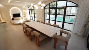 a dining room with a white table and chairs at Grand De Raj in Angeles