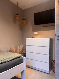a bedroom with a dresser and a tv on the wall at Modern Good Location in Hamburg