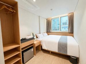 a bedroom with a bed and a desk and a window at Sonoće Hostel Seoul - Private Bathroom & Premium in Seoul