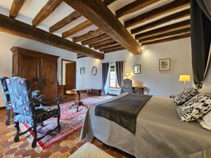 a bedroom with a bed and a chair in a room at Château de Ribourdin in Chevannes +60 photos