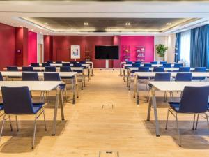 a conference room with tables and chairs and a screen at Novotel Barcelona Cornellà in Cornellà de Llobregat