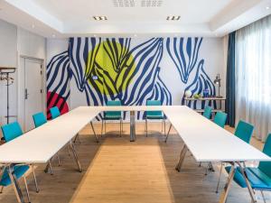 a conference room with white tables and blue chairs at Novotel Barcelona Cornellà in Cornellà de Llobregat +162 photos
