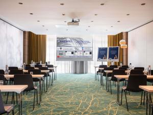 a room with tables and chairs and a projection screen at Novotel Paris 17 in Paris