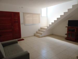 a living room with stairs and a couch and a television at Renzo 1 in Deán Funes