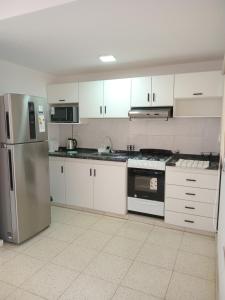a kitchen with white cabinets and a stainless steel refrigerator at Renzo 1 in Deán Funes
