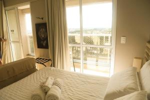 a bedroom with a bed and a large window at Studio Premium - Bairro Nova Yorque Araçatuba in Araçatuba +67 photos