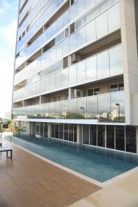 an external view of a building with a swimming pool at Studio Premium - Bairro Nova Yorque Araçatuba in Araçatuba