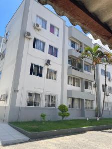 a white building with a palm tree in front of it at Campinas in São José