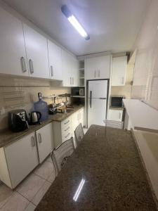 a kitchen with a table and a white refrigerator at Campinas in São José
