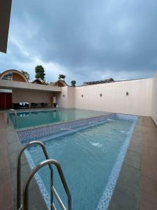 a large swimming pool next to a building at Pakuhaji Highland Ecoresort in Panjadakan