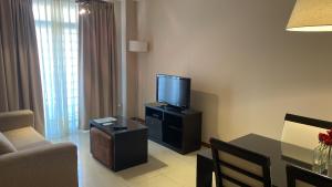 a living room with a television and a table with a couch at Zárate Temporarios in Zárate