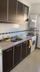 a kitchen with a sink and a stove at Zárate Temporarios in Zárate