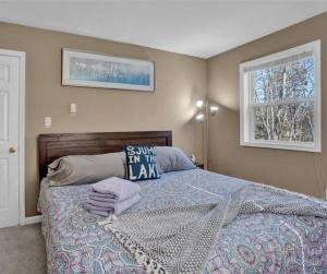 a bedroom with a bed with a pillow on it at Arrowhead Lakefront Chalet Private Lake Access in Pocono Lake +56 photos