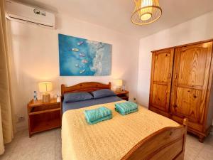 a bedroom with a bed with two pillows on it at Fibonacci Beachfront Apartment in Flic-en-Flac