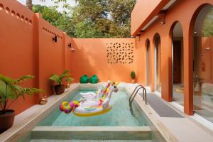 an orange house with a pool with an inflatable pool slide at เพลาวิลล่า in Langu +14 photos