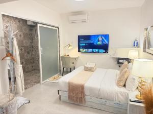 a bedroom with a bed and a tv on the wall at Studio Crème by The Prime Escape in Arusha