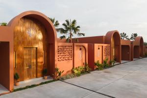 a building with arches and a wooden door at เพลาวิลล่า in Langu
