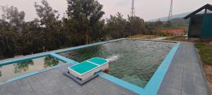 a pool of water with a chair in the middle at wild grove resorts in Varagampadi +42 photos