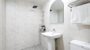 a white bathroom with a sink and a mirror at sotam stay hotel in Taeam +9 photos
