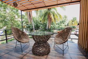 a patio with a glass table and two chairs at Paulas Suites Terraza in Ixtapa