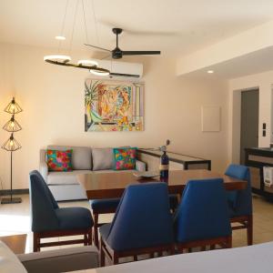 a living room with a couch and a table and blue chairs at SUITES LOMBOY & PLAZA in San José del Cabo
