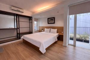 a bedroom with a bed and a large window at The Charm Boutique Hotel Hue in Hue