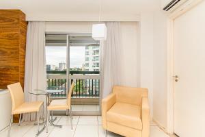 a living room with a table and chairs and a balcony at Vision Hotel em Brasília 60300 in Brasília