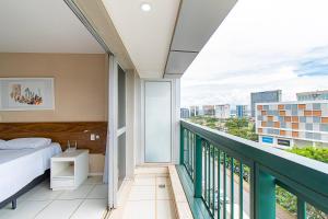a bedroom with a bed and a balcony at Vision Hotel em Brasília 60300 in Brasília