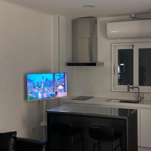 a kitchen with a flat screen tv on the wall at momohouse 체스룸 in Chinyŏng-yŏk +16 photos