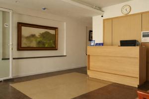 a waiting room with a desk and a clock on the wall at The Charm Boutique Hotel Hue in Hue