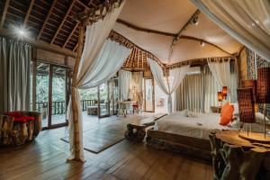 a bedroom with a canopy bed and a table at Kropak Canggu in Canggu +91 photos