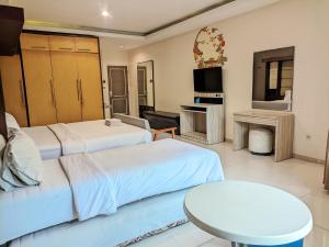 a hotel room with two beds and a table at K Residence Surabaya in Surabaya