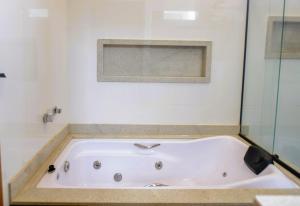 a white bath tub in a bathroom with a window at Casa com Piscina Aquecida Churrasqueira e Hidro in Franca