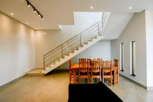 a dining room with a table and a staircase at Casa com Piscina Aquecida Churrasqueira e Hidro in Franca
